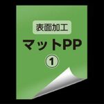 Green product label with Japanese text '表面加工' and 'マットPP', a circled number 1, and a curled corner indicating a folded page.